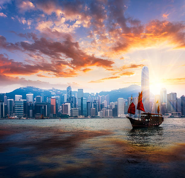 Junkboat  of hong kong Traditional Chinese Junkboat sailing across Victoria Harbour at sunset,  Hong Kong the bank of china tower stock pictures, royalty-free photos & images