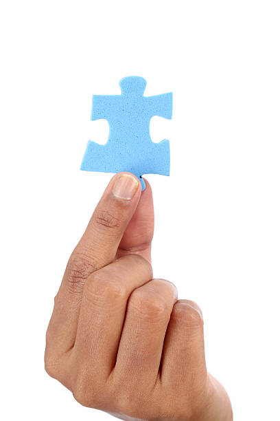 mano con rompecabezas azul sobre blanco - portion blue jigsaw puzzle puzzle fotografías e imágenes de stock