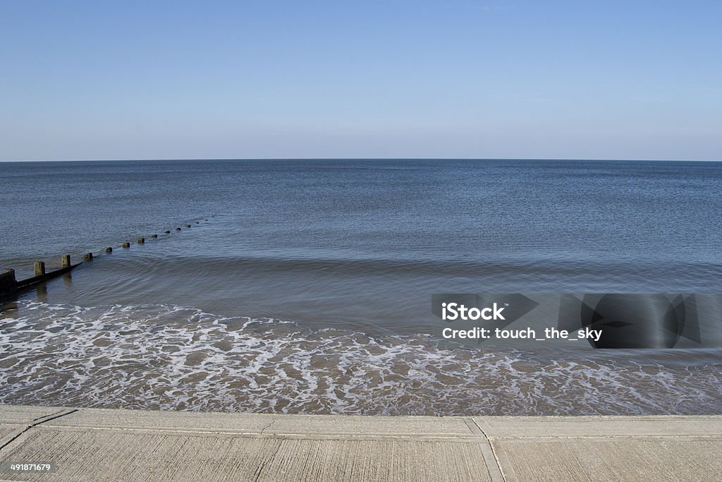 Incoming tide Waves hitting the concrete sea wall as the water level increases Beauty In Nature Stock Photo