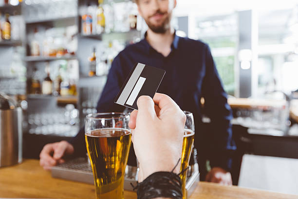 istock Man paying for beer by credit card in the pub 491872444
