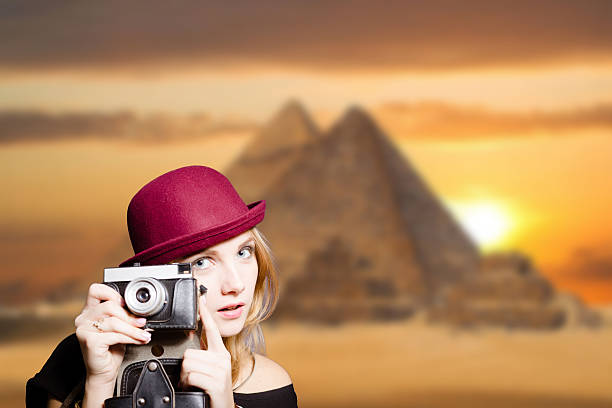 istock Girl in glasses with retro camera on Egypt pyramid background. 491872714