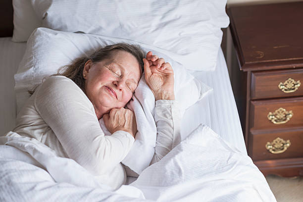istock Senior woman asleep in bed 491873358