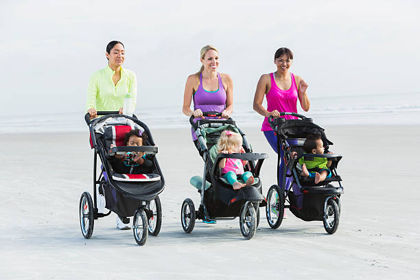 istock Three mothers and babies in strollers jogging on beach 491873584