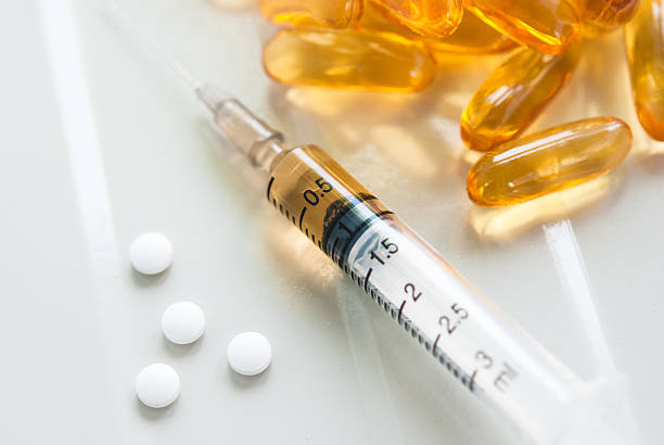 istock Syringe and colorful pills 491873897
