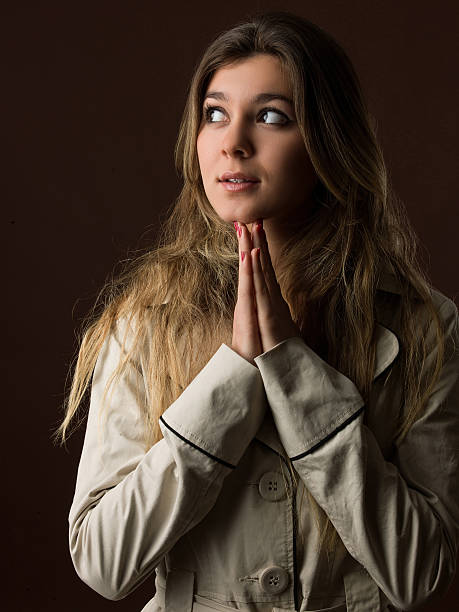 istock Young girl praying over dark background 491874184