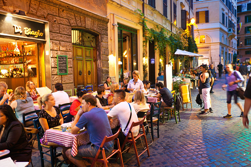 Tourists enjoy an afternoon meal along the shores of Lake Como at a sidewalk cafe at the waterfront Piazza Giuseppe Mazzini in the colorful town of Bellagio, Italy. Bellagio is a village on a promontory jutting out into Lake Como, in Italy. It’s known for its cobbled lanes, elegant buildings and Villa
