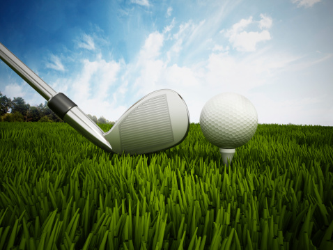 Golf ball, tee and club standing on grass.