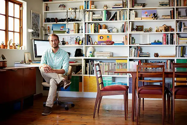 Portrait of man by computer in living room