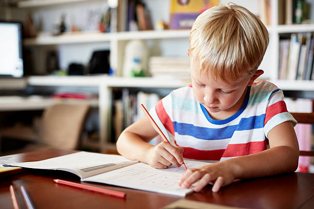 boy coloring at table - concentration contemplation clothing viewpoint fotografías e imágenes de stock