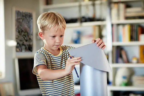 Concentration boy building rocket at home in living room