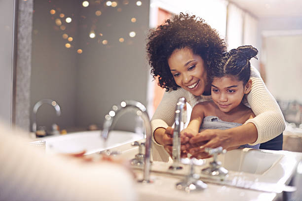 lernen sie die bedeutung von waschen ihre hände - mirror mother bathroom daughter stock-fotos und bilder