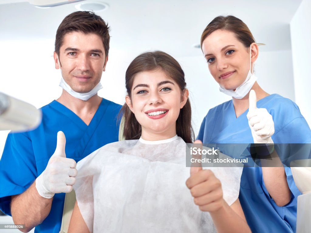 Dentists and patient making sign to confirm Dentists and patient making sign to confirm. 2015 Stock Photo