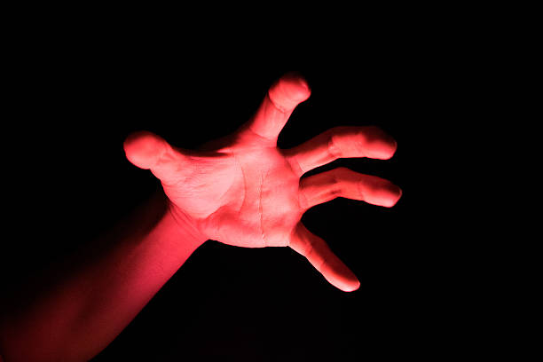 istock Hand Reflective red light in the dark background for scary 491888578