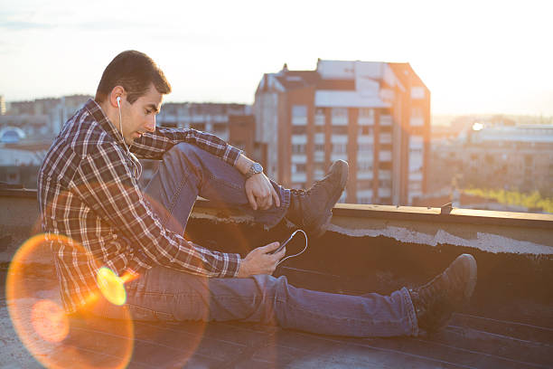 istock Young man listen music in sunset 491890841