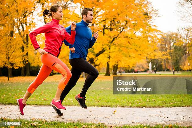 Couple Jogging In Autumn Nature Stock Photo - Download Image Now - Running, Autumn, Jogging