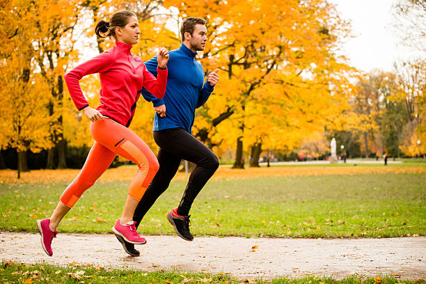 casal jogging no outono natureza - running women jogging profile imagens e fotografias de stock