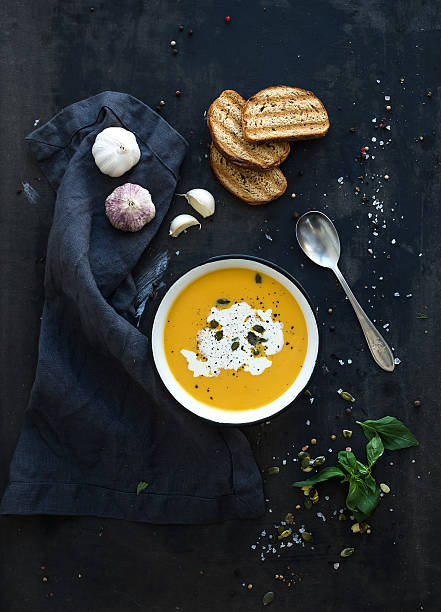 istock Pumpkin soup with cream, seeds, bread and fresh basil on 491891256
