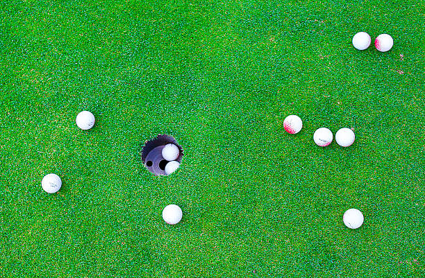 istock golf balls on green grass in golf course 491892158