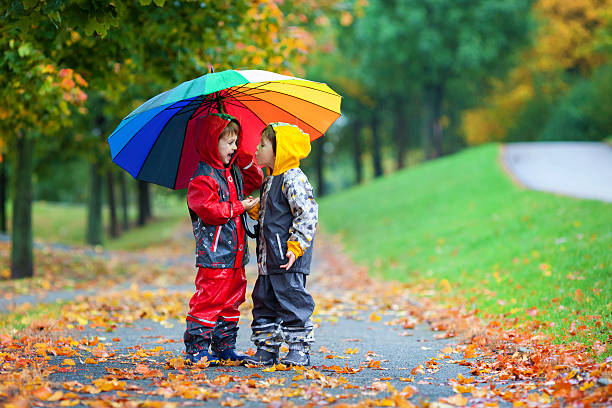 istock Two adorable children, boy brothers, playing in park with umbrel 491893330