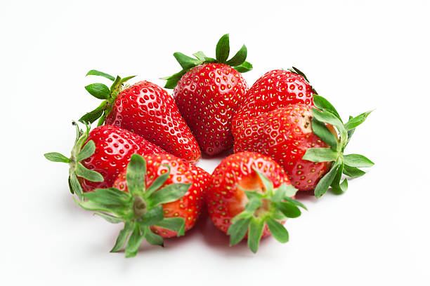 Strawberries in glass cup on light background stock photo