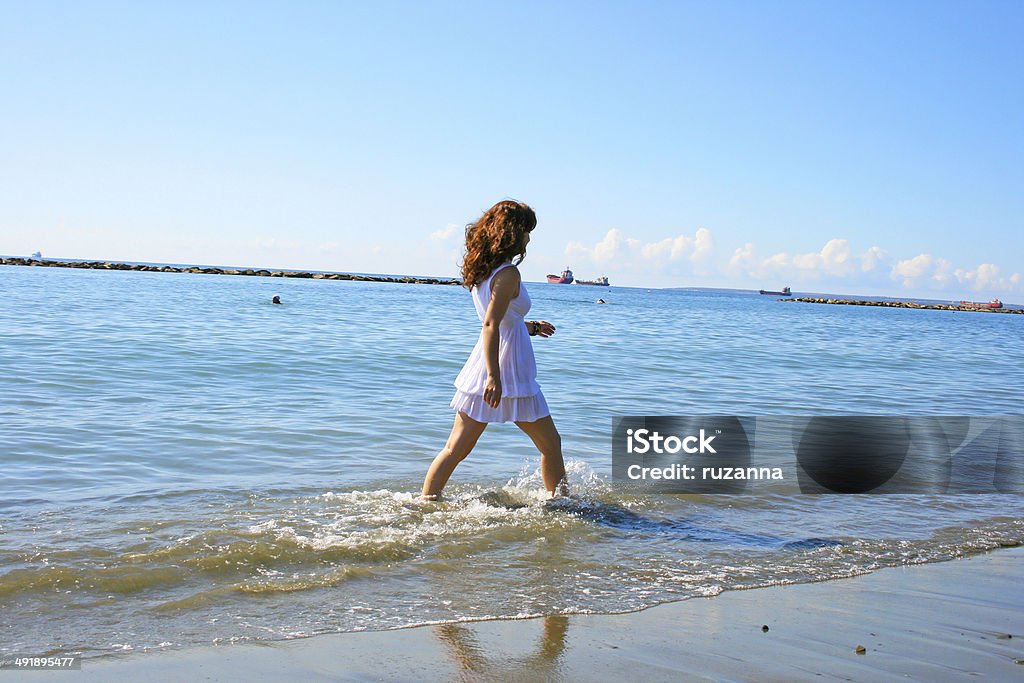 Woman on beach Pretty woman in white dress on beach in Limassol, Cyprus. Adult Stock Photo