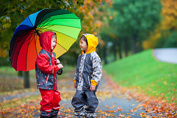 istock Two adorable children, boy brothers, playing in park with umbrel 491904064