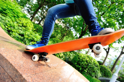skateboarding  woman jump on ramp in skateboard park