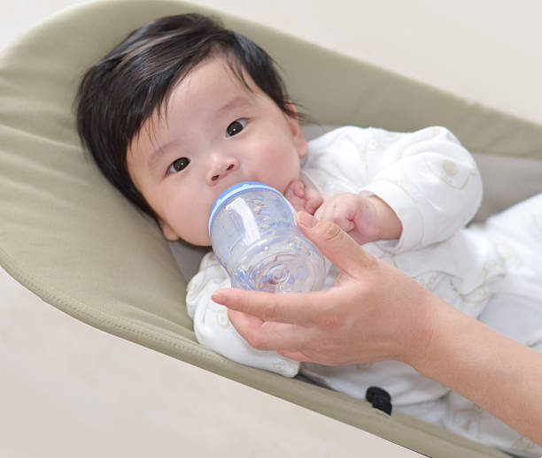 istock feeding milk with baby bottle 491911967