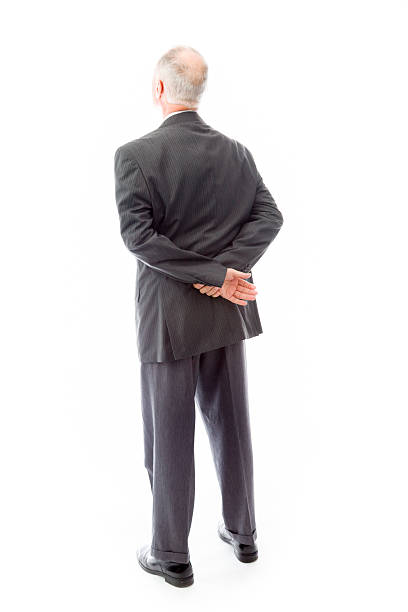 Rear view of a businessman thinking Rear view of a businessman thinking hands behind back stock pictures, royalty-free photos & images