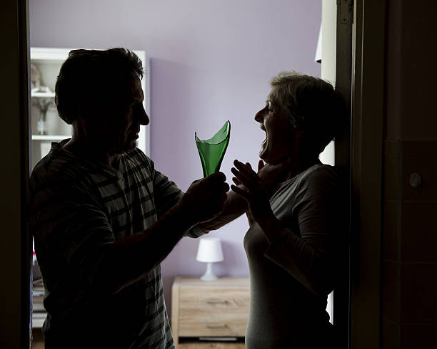 Domestic violence Silhouette of mature couple fighting, the man is attacking woman with broken bottle. Woman is victim of domestic violence woman strangles man stock pictures, royalty-free photos & images