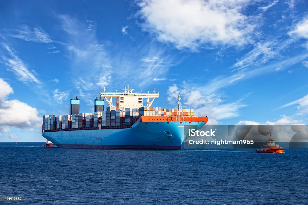 Tugboat towing container ship Tugboats assisting container cargo ship to harbor. Ship Stock Photo