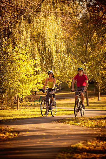 istock Autumn Bicyclists Cycling Exercising in Park Bicycle Path 491919880