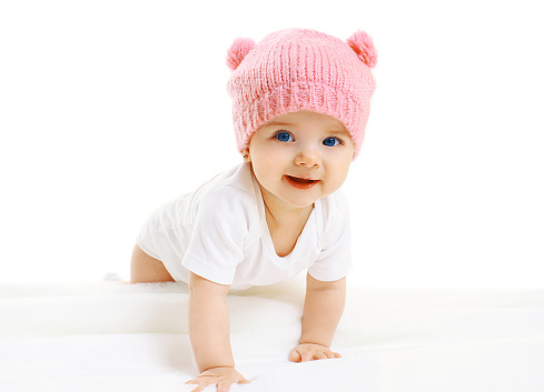 Portrait of sweet baby crawls in the pink knitted hat