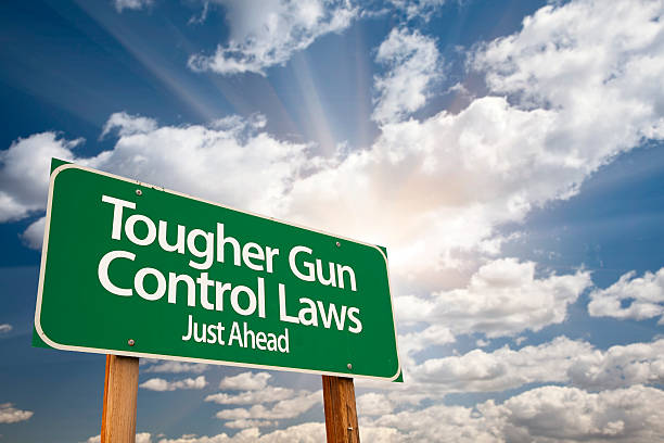 istock Tougher Gun Control Laws Green Road Sign Over Clouds 491920706