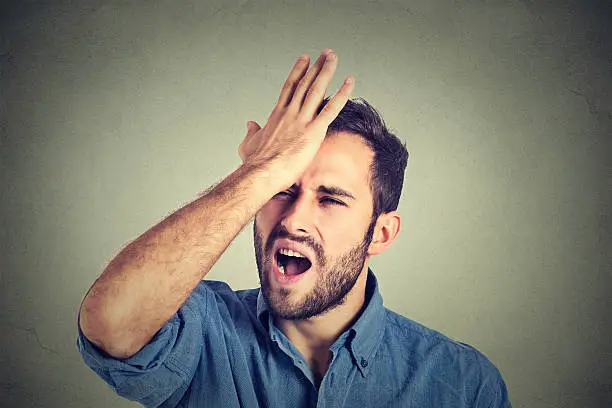 Regrets wrong doing. Closeup portrait silly young man, slapping hand on head having a duh moment isolated on gray background. Negative human emotion facial expression feeling, body language, reaction