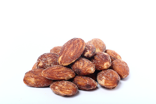 salted and roasted almonds isolated on white background