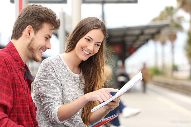 istock Couple of students studying in a train station 491923438