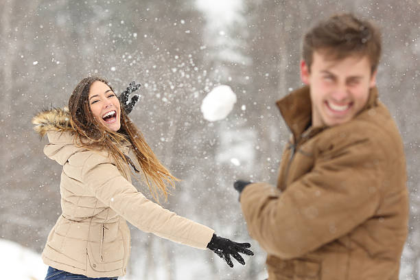 casal brincando com neve e namorada jogando uma bola - snowball snow play throwing - fotografias e filmes do acervo