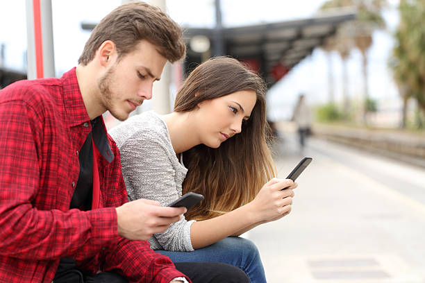 istock Teens obsessed with smart phones in a train station 491924022