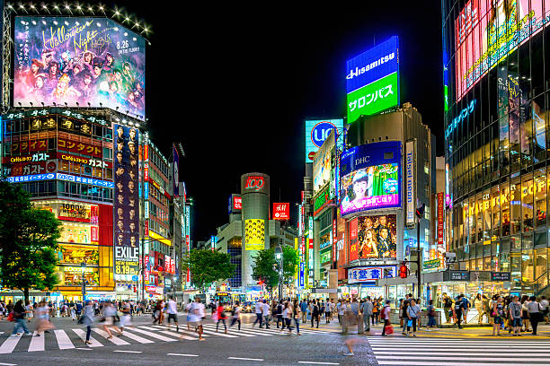 Busy Shibuya crossing in Tokyo People crossing the famous Shibuya crossing in Tokyo at night. tokyo prefecture stock pictures, royalty-free photos & images