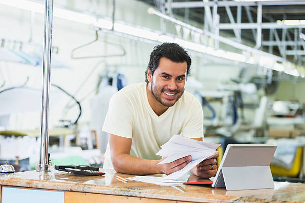 Hispanic small business owner, dry cleaner paying bills
