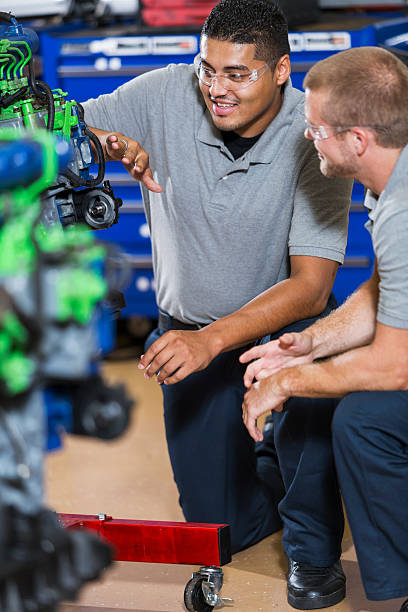 istock Two multi-racial men in auto mechanic school with engine 491933416