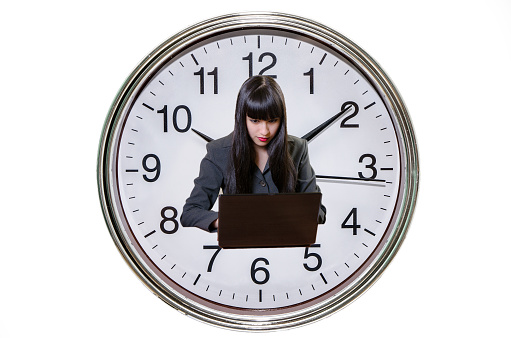 Business woman  working on laptop  within a big clock background