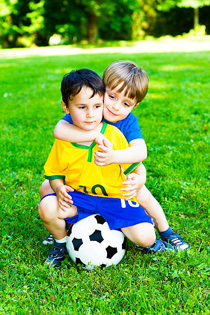 istock Two toddlers hugging sitting on soccer ball 491938503