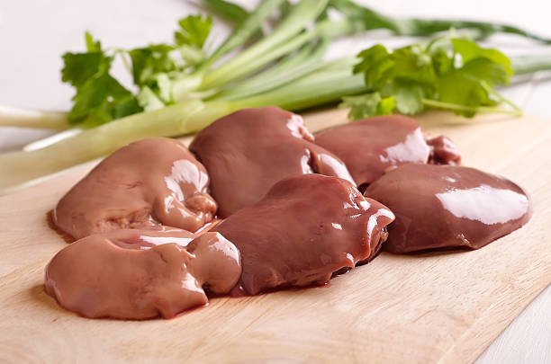 Raw chicken liver on cutting board stock photo