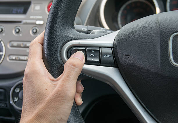 istock hand pushes the cruise control button on a steering wheel. 491939192