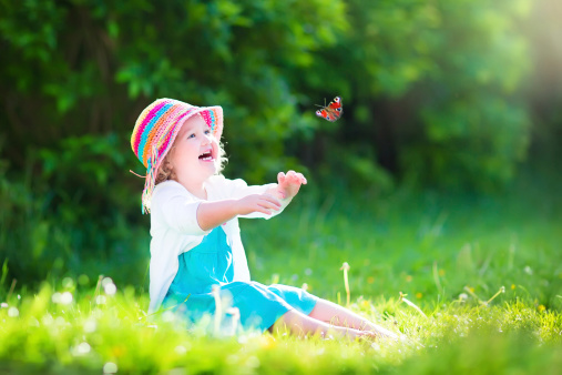 Little toddler girl playing with butterfly