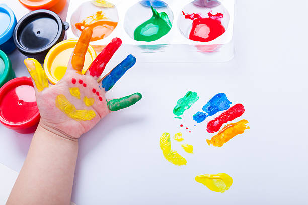 istock Child paint her palm with smiling face various colors. 491946200