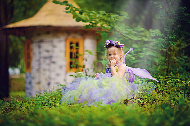 Cute little girl in fairy costume with pink wings on beige background, space for text