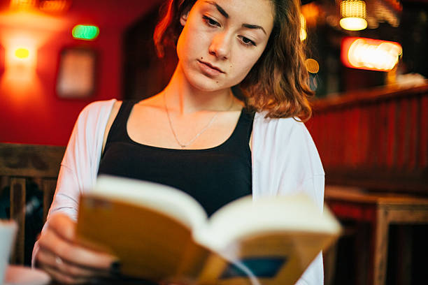 istock Girl reading a book in cafe 491948126